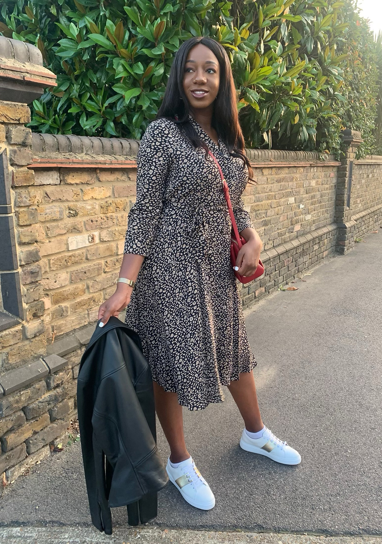Hobbs Senior Digital Designer, jessica King wears the camel and navy rosaline midi dress with white trainers and a leather jacket 
