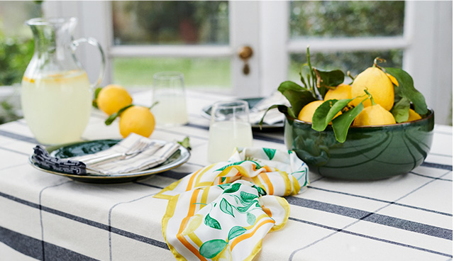 Kitchen worktop displayed with a jug of lemonade, a bowl of lemons and Hobbs lemon print scarf.