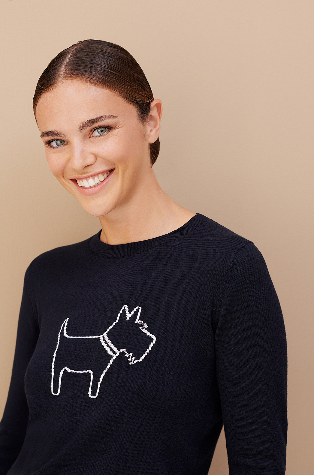 Model wears a novelty jumper featuring a dog from Hobbs.