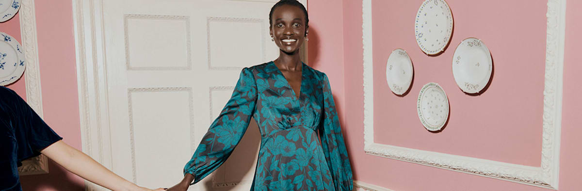 An image of a model wearing a teal satin occasion dress.