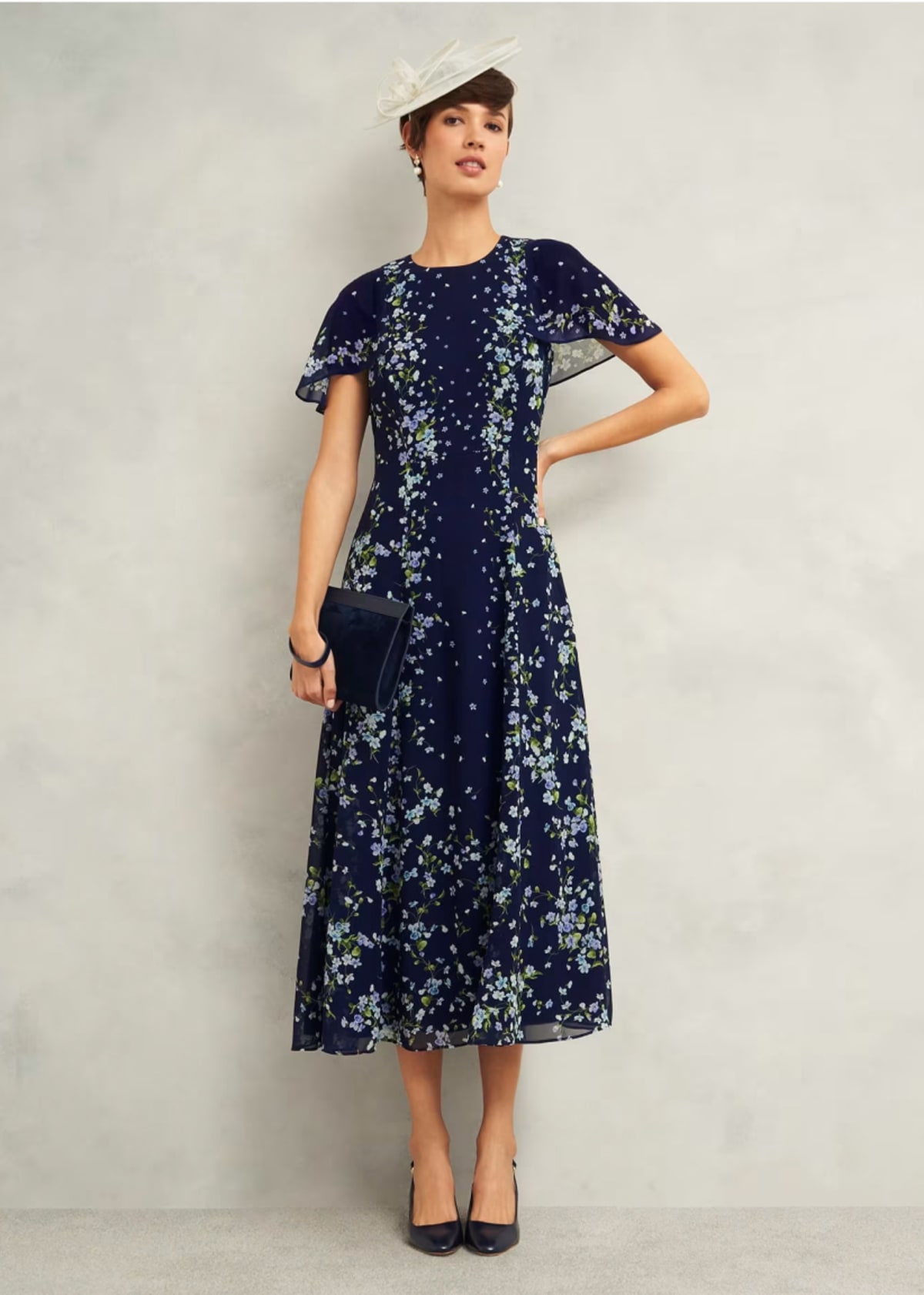 A gallery of four images of models wearing occasion floral midi dresses and coordinating accessories.