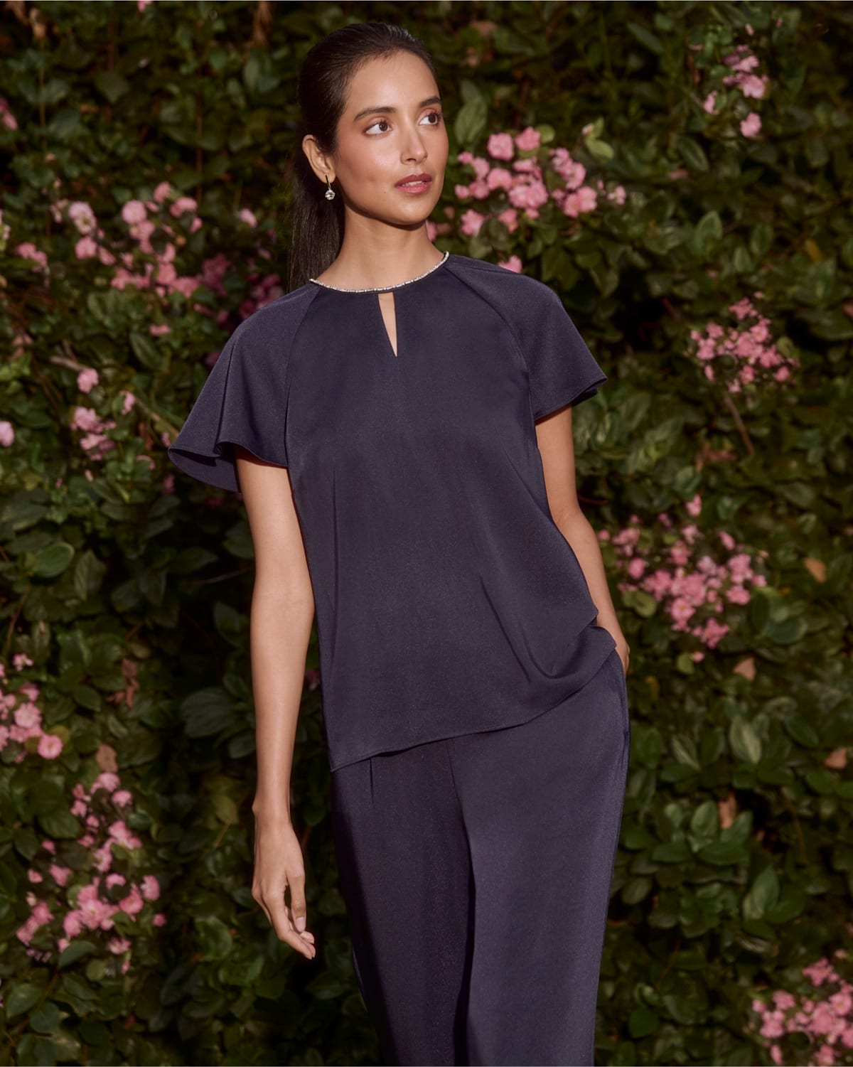A collage of two images showing a model wearing a navy satin two piece.