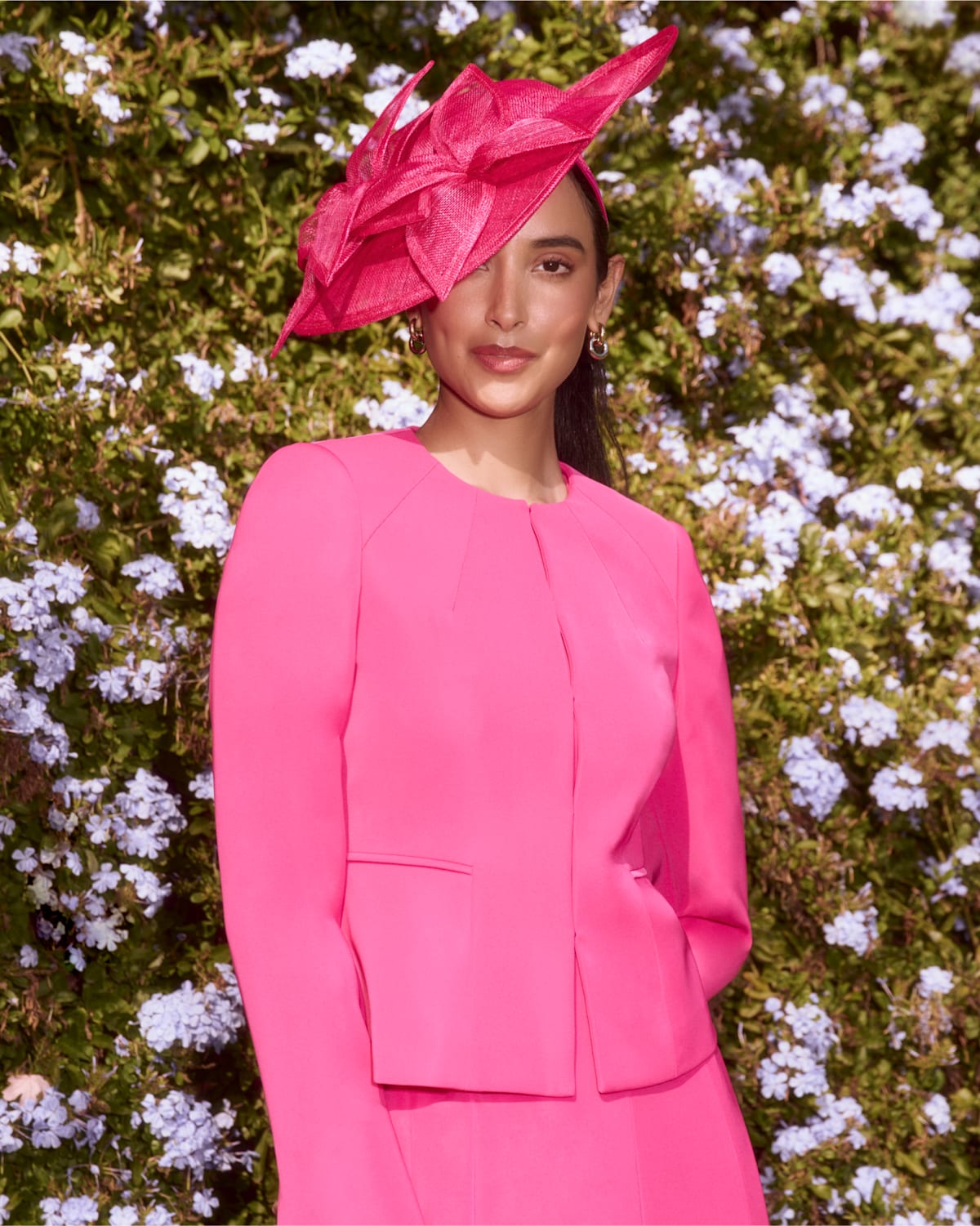 An image of a model wearing a pink occasion outfit and coordinating fascinator by Hobbs.