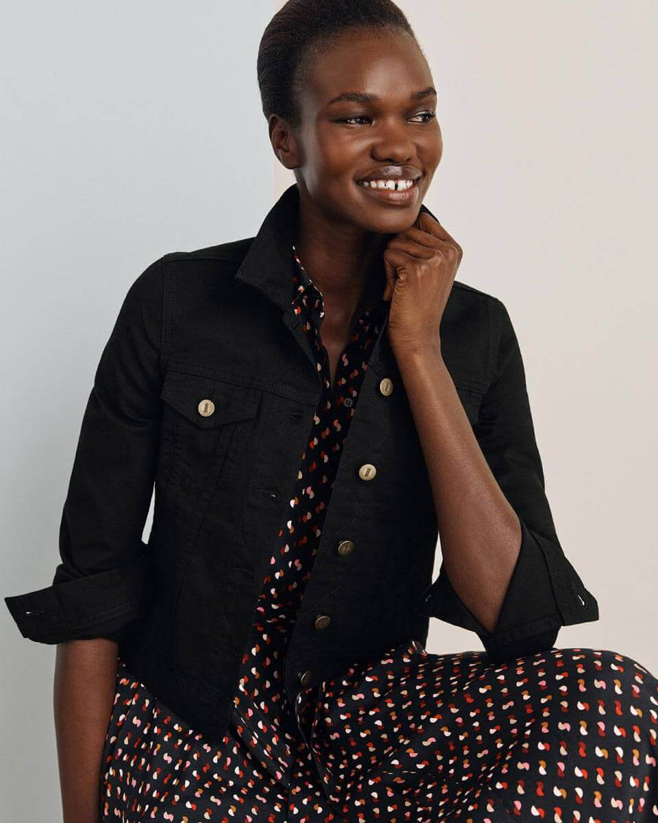 Hobbs model photographed wearing an abstract print shirt dress and black denim jacket.