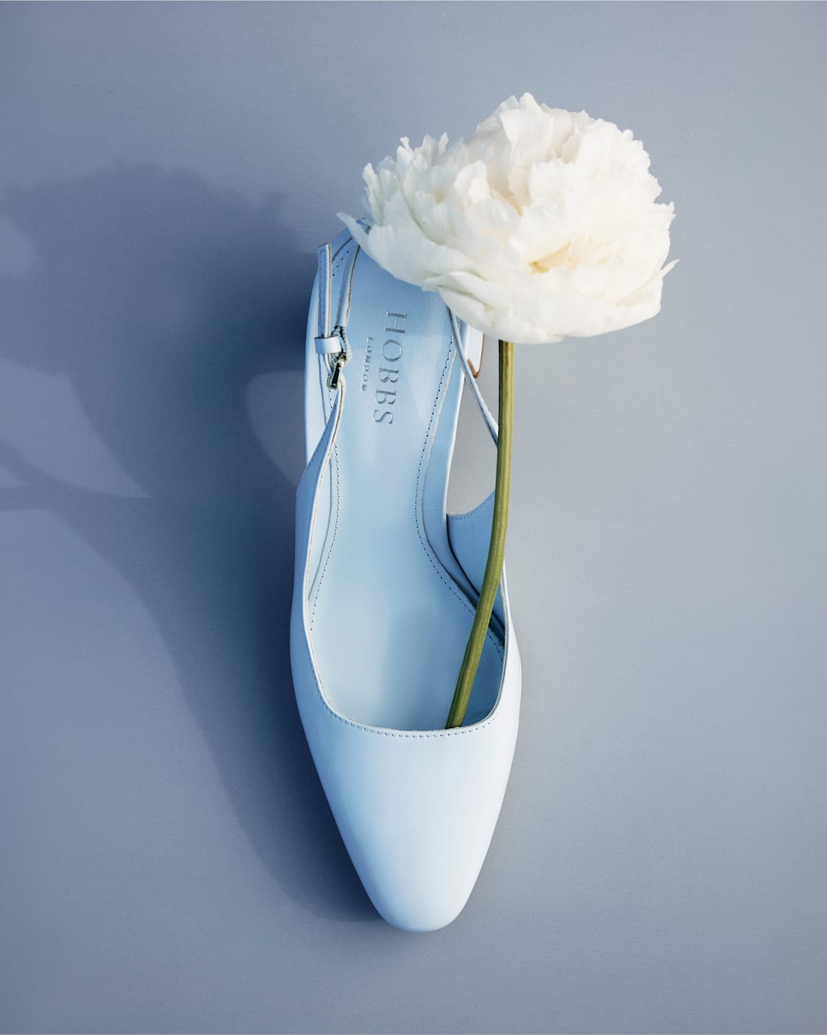 A gallery of two images of a pair of blue block heels by Hobbs.