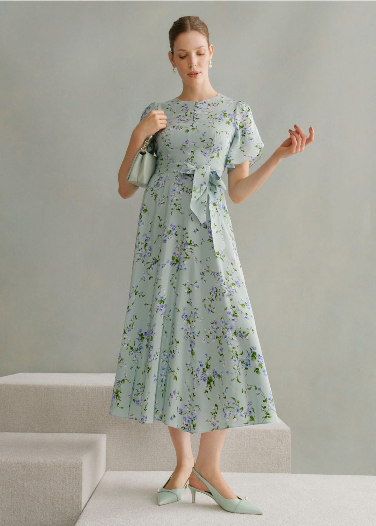 A gallery of two images of models wearing occasion floral midi dresses.
