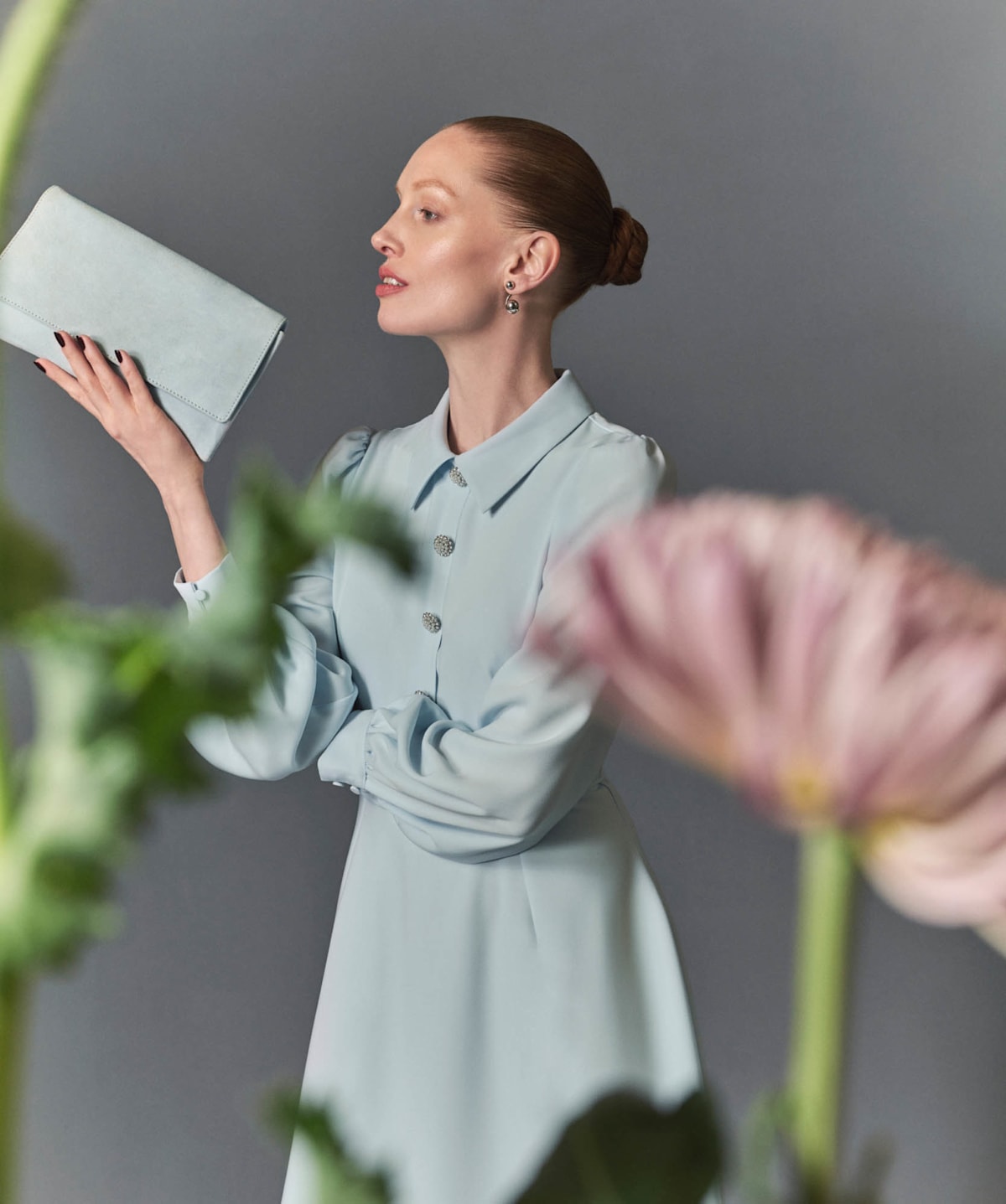 Image of model wearing a long sleeve occasion dress and matching bag.
