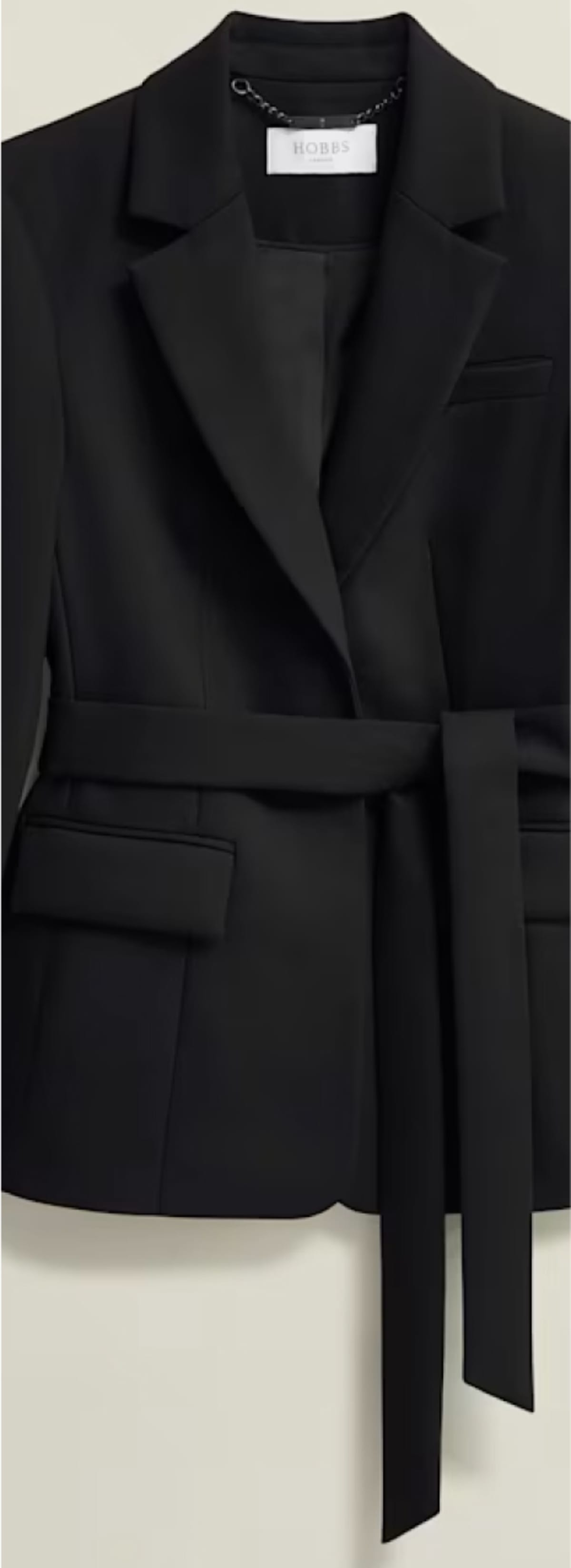 A gallery of four images including one image of a model wearing a women’s black suit, and three smaller images displaying details of the blazer.