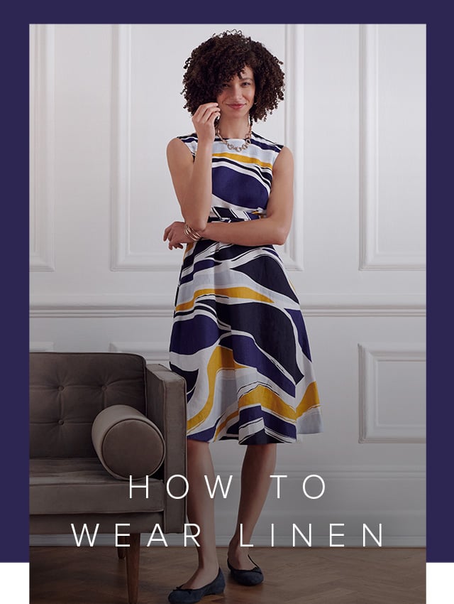 Photographed next to a contemporary armchair, model wears a printed fit and flare linen dress.